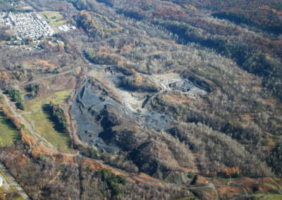 Aerial of 200 acres of mine-scarred land, surrounded by trees and residential neighborhood in upper-left-hand corner.