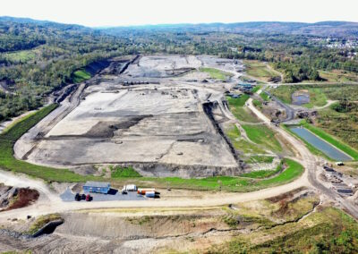 Aerial view of large flat construction site with heavy machinery flattening pad