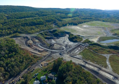 Aerial view of mostly dirt, unreclaimed site with irregular topography, including steep slopes, banks, and pits.